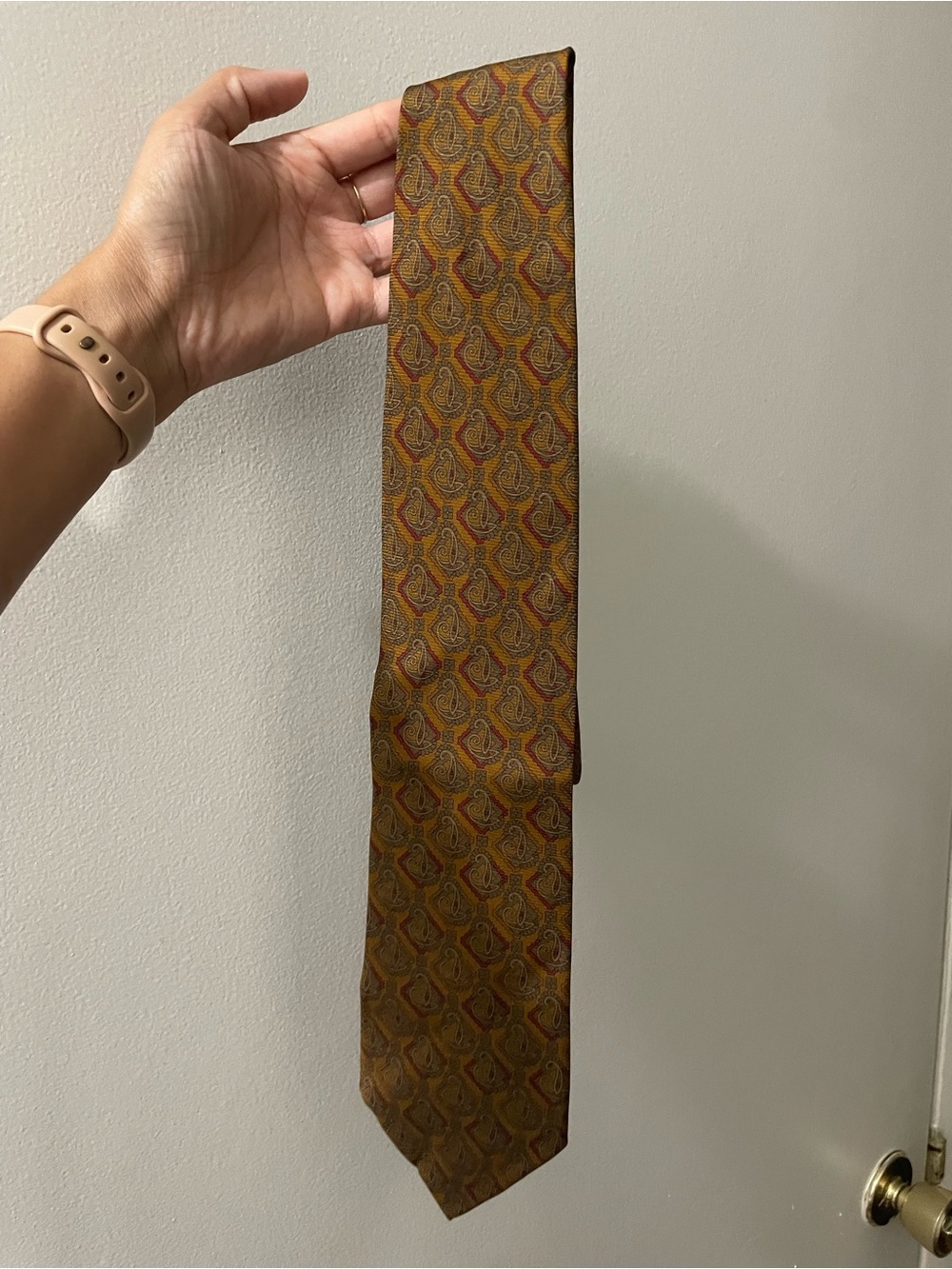 This is a Paul Stuart New York necktie featuring a gold and red paisley pattern